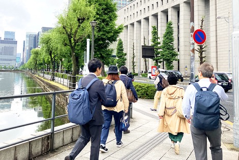 従業員がオフィス街の歩道を歩いている様子